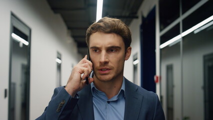 Handsome manager arguing phone call portrait. Annoyed professional walk office