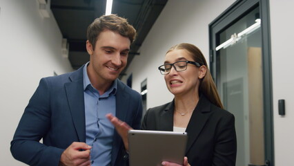 Happy businesswoman sharing results analysing tablet data. Business team discuss