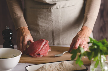 Close-up of a woman's hands ready to prepare Argentinian milanesas.