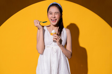 ice cream lover summertime happiness attractive asian female woman in white summer dress hand hold sweet ice cream smiling enjoy leisure dessert summer relax fun and carefree woman travel vacation 