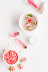 Fototapeta na wymiar Pink roses cosmetic products set with flowers essential oil. Beauty care concept.