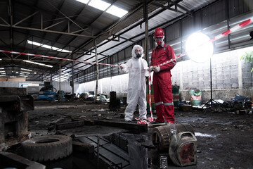 workers in a factory. Employees are barricading the area to dispose of hazardous substances. in a chemical protective suit in a factory