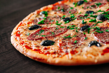 Pizza with Mozzarella cheese, salami, Tomato sauce, pepper, Spices. Italian pizza on wooden table background