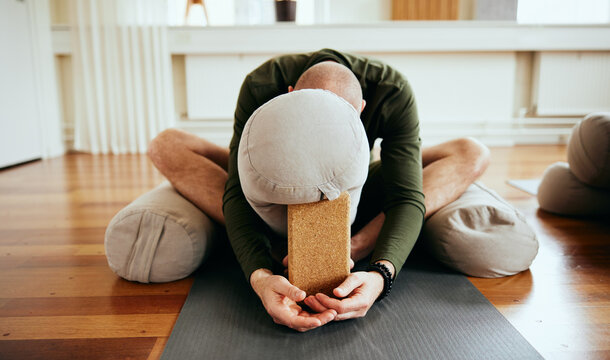 Man doing restorative yoga in a class