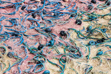 Mixture of colorful fishing nets, floats and ropes. Fisherman material background.