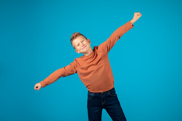 Fototapeta na wymiar Portrait Of Funny Little Boy Spreading Arms And Pretending Flying