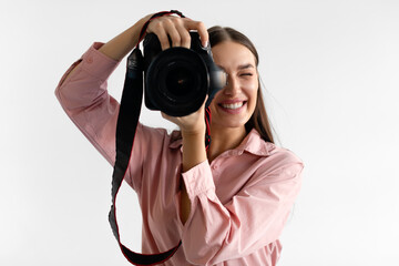 Closeup portrait of young woman photographer taking photo, lady working in photostudio, using professional dslr camera
