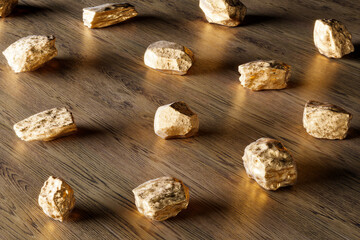 A group of pure gold pieces on the wooden background. Golden nuggets. Gold ore