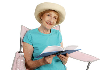 A pretty senior lady relaxing in a beach chair with a good book.  Isolated on white.