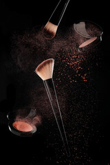 cosmetic powder and a brush on a black background 