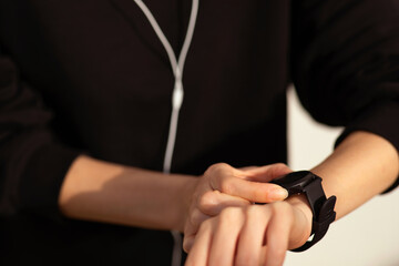 Millennial european woman athlete in sportswear and headphones enjoys music and workout, checks heart rate