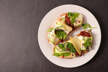 Bruschetta, bread toast, canape with cream cheese, zucchini and dried tomato with herbs