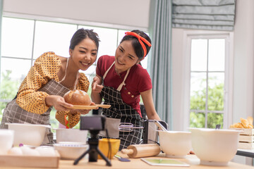A woman is showing a bread that she has made to her friend.