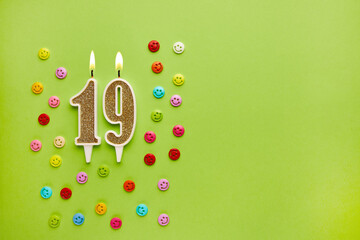 Number 19 on a pastel green background with colored emoticons. Happy birthday candles. The concept...