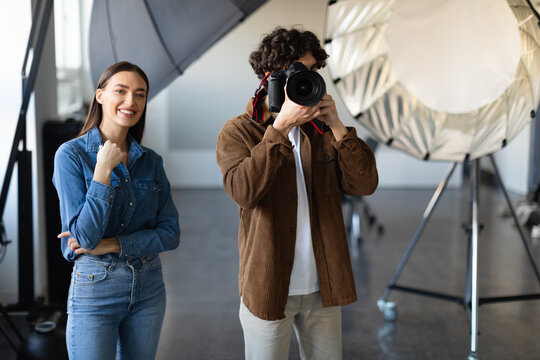 Capturing the moment. Male photographer with his trusty assistant doing photo shoot in studio