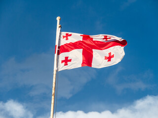 Georgian Flag flying against a blue background on a windy winter morning
