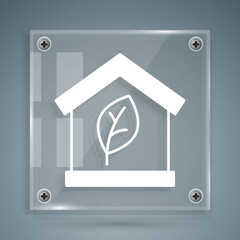 White Eco friendly house icon isolated on grey background. Eco house with leaf. Square glass panels. Vector