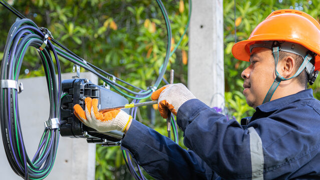 Engineer or technician checking fiber optic cables in internet splitter box.Fiber to the home equipment. FTTH internet fiber optics cables and cabinet..