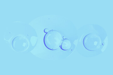 round drops of transparent gel serum on a blue background. gel with bubbles. Water droplets