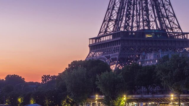Eiffel Tower and the Seine river night to day transition timelapse before sunrise, Paris, France. Morning close up view from Bir-Hakeim bridge with reflections on water