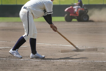 野球のグランドをトンボでグランド整備する選手 © Asphalt_STANKOVICH