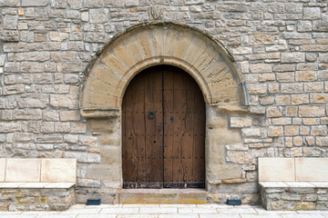 Fototapeta na wymiar L'Astor (Anoia), Catalunya, Spain - May 14, 2023: Front door of Santa Magdalena Church 