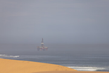 scenic view of the Namib desert with an oil rig in the background