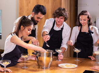 Chef teaching trainees how to make ice cream. Cooking tasty ice cream dessert made from chocolate and vanilla in glass bowl