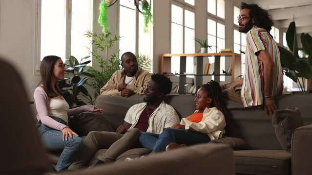 group of multiracial people coworkers, in modern coworking sitting on sofa talking at meeting, college students