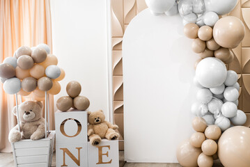 Arch decorated with golden, white balloons and soft teddy bears for birthday party. Celebration...