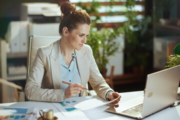 accountant woman in light business suit in green office
