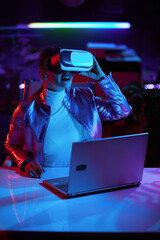 smiling stylish female in virtual reality goggles in office