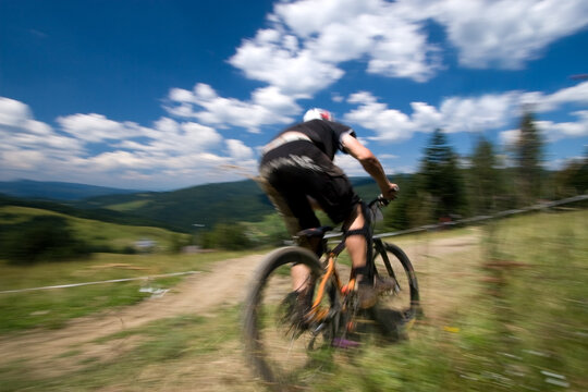Male mtb biker during downhill event in motion blur