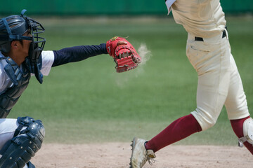 野球の試合中にバッターが見送ったピッチャーが投げたワンバンしたボールを体を張って止めるキャッチャーと土煙が上がる瞬間