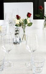 Elegant table setting with red roses and white linen.