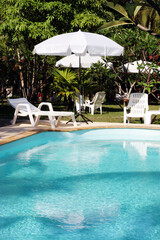 Swimming pool with deck chairs and umbrellas.