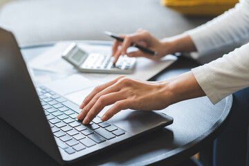 Deduction planning online asian young woman hand using calculator and laptop to calculate balance...