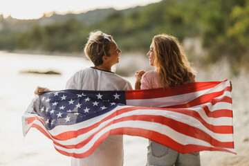 Two Women With US National Flag Enjoying Day On The Beach