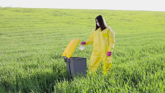 Woman throwing away plastic bottle in garbage can. Environmental damage by plastic waste.Environmental conservation