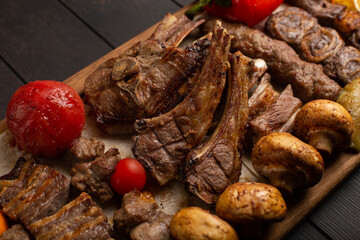 Assorted different types of halal meat made on the grill. Roast lamb, kebab, beef, mushrooms, tomatoes, onions and peppers. Close-up.