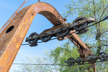 Wheel abandoned cableway for transporting people in amusement park. Old obsolete suspension road across river. Vintage rusty cable car in the city Dnepr. Soviet union technology and attractions USSR.
