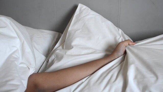 woman hands squeezing pillow passionately illustrating sex intimacy