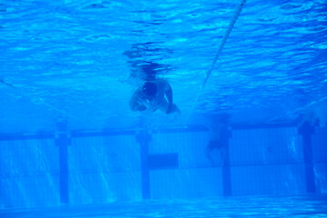 undervater shoot of swimming pool with good looking young swimmer