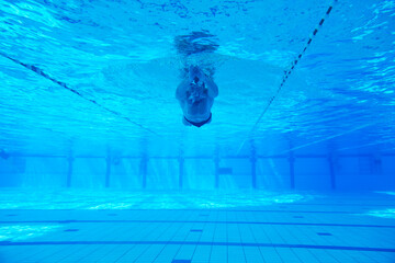 undervater shoot of swimming pool with good looking young swimmer