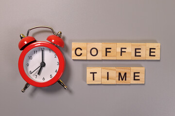 Coffee time inscription and alarm clock on gray background
