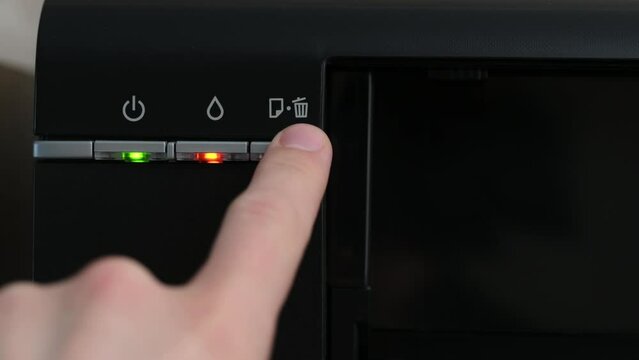 The indicators on the printer are red,the printer is broken,the man knocks on the printer,close-up.Multifunction printer