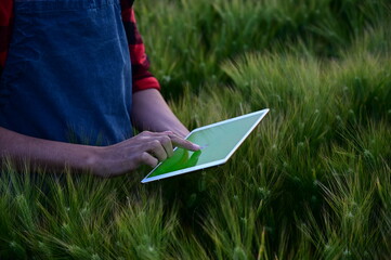 Man using tablet at field. Future of Agriculture: The New Face of Efficient Farming Managed by Tablets.