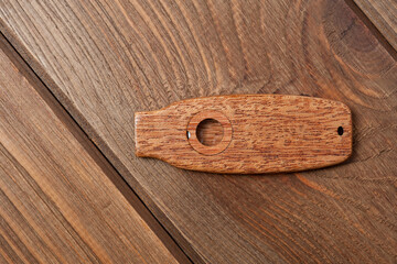 Kazoo is a musical wind instrument made of wood, filmed on a wooden surface.