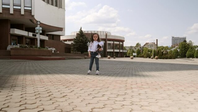 The child walks around the city square.