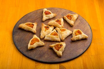 Sweet gomentashi cookies for the holiday of Purim on a chalkboard are laid out on a chalkboard in the form of magen David on the table.